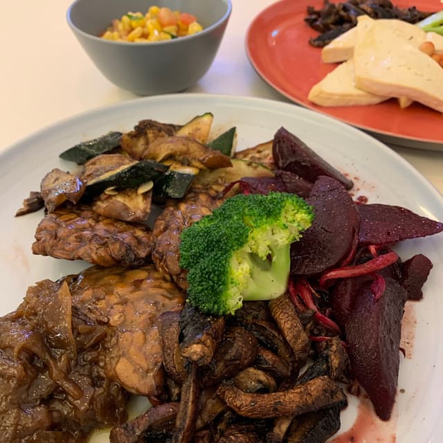 Photo of the dish “Baked Tempeh, Caramelized Onions, Roasted Seasonal Veggies, Portobello Mushrooms, Beetroot Salad, Corn Salsa”