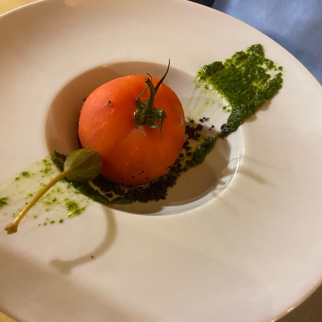 菜肴“Scrigno di pomodoro ripieno di olive con salsa al prezzemolo”的照片