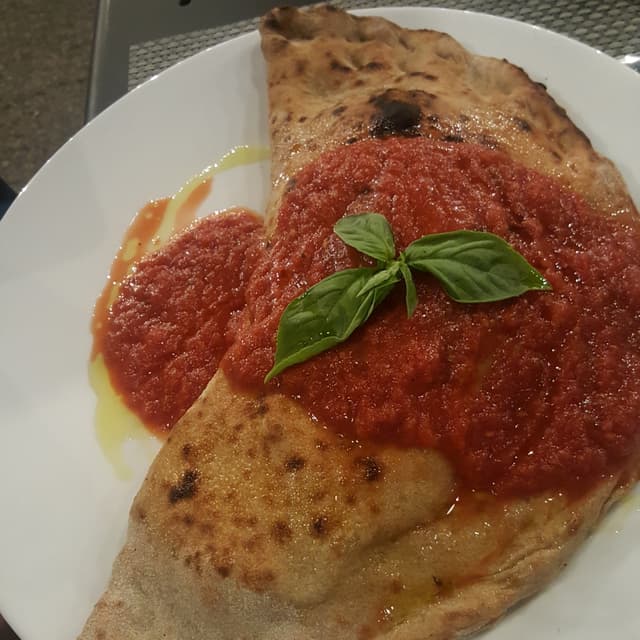 菜肴“Calzone farcito Funghi Formaggio Veg Salsiccia Veg. Pomodoro e Basilico”的照片