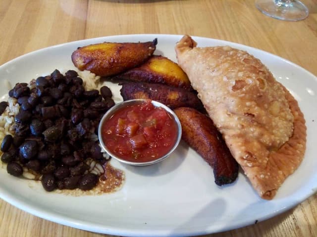 Photo of the dish “Breakfast Empanada. Stuffed with scramble, potato, bac'n, cheddar; served with plantains & black beans & rice”