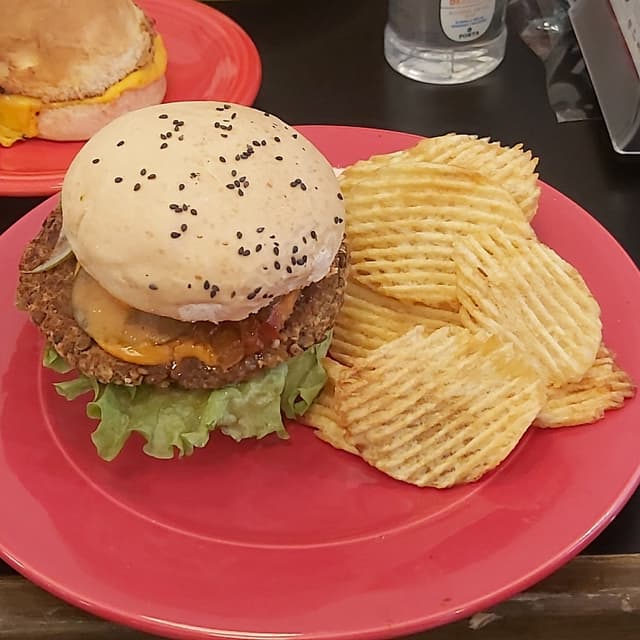 Photo of the dish “Hamburguesa de lentejas, cheddar vegano, tomate, lechuga, pepinos y porción de papas”