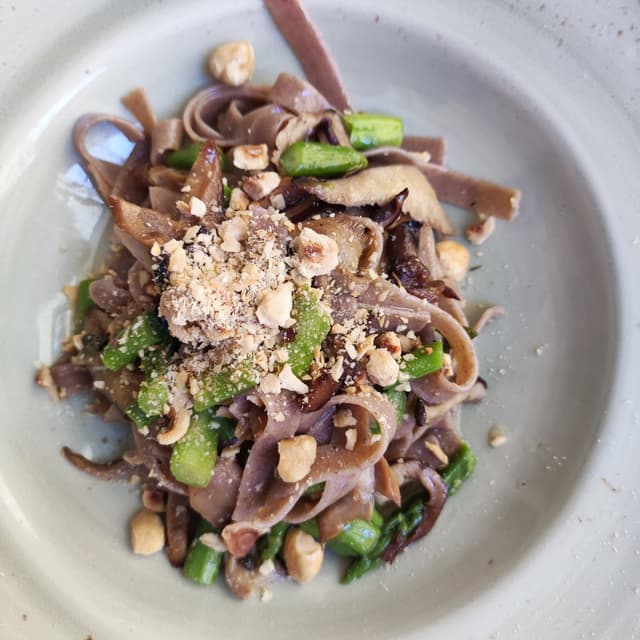 菜肴“Pappardelle di Farro con funghi cardoncelli, asparagi e nocciole tostate”的照片