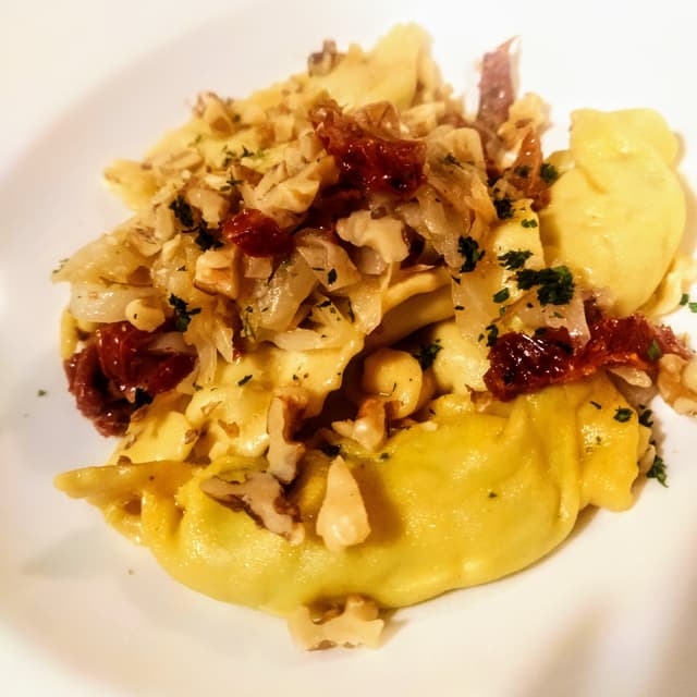 Photo of the dish “Caramelle ripiene di cime di rapa, spadellate con cavolo cappuccio, pomodori secchi e scaglie di noci”