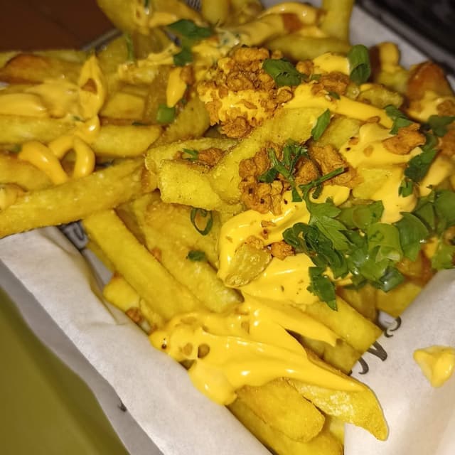 Foto del plato “Batata frita com molho cheddar e soy bit bacon”