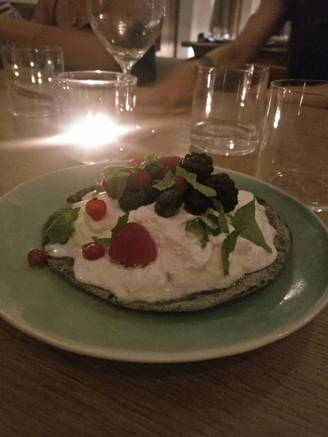 Photo of the dish “Activated carbon vegan "coca" with coconut whip cream and redfruits”