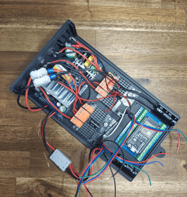 forum_update __ Panneau électronique ouvert avec divers composants et câbles colorés.