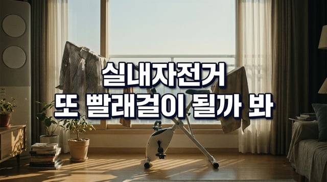 거실에 놓인 접이식 실내자전거에 빨래가 걸려 있는 장면