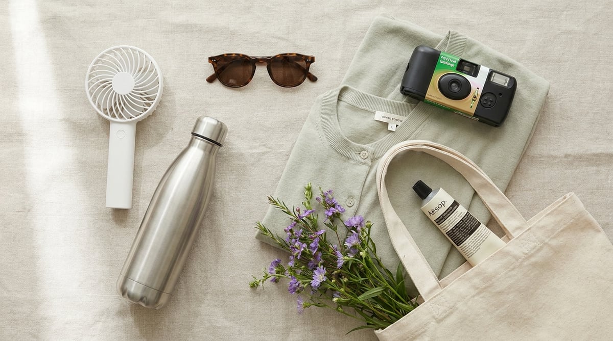 5월 당일치기 가방 플랫레이 — 손풍기, 물병, 선크림, 카디건