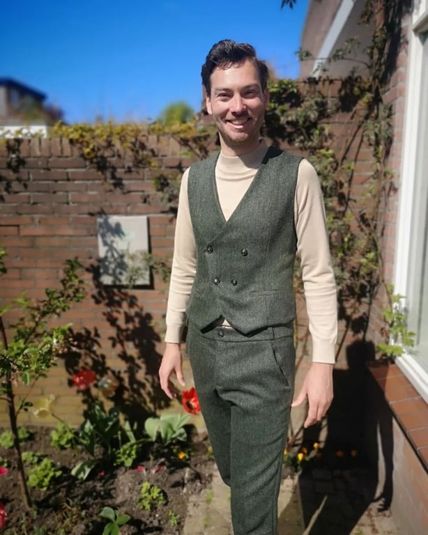 Rob in a sunny backyard garden, wearing an adjusted Wahid with a double breast and matching Charlie trousers.