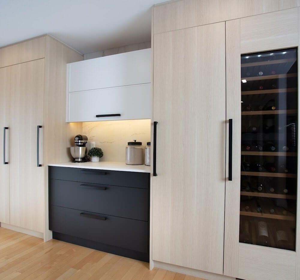 Light oak kitchen cabinetry with black drawers, a built-in wine fridge, and a lit coffee nook in Lakeshore North.