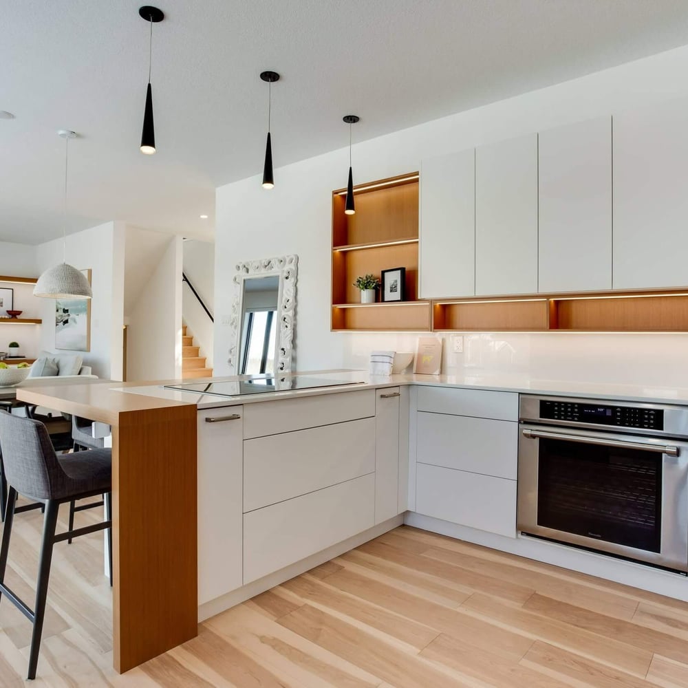 41Z9HsKg Modern kitchen with white cabinetry, a central island, stainless steel appliances, and wooden accents, featuring pendant lighting and a light wood floor.
