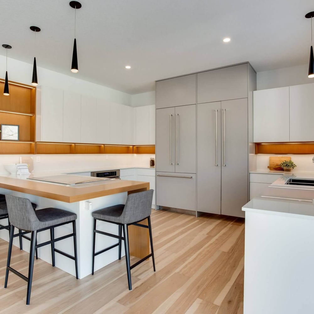4IiaOO_Q Modern kitchen with sleek cabinetry, an island with seating, and stainless steel appliances in a bright, open layout.