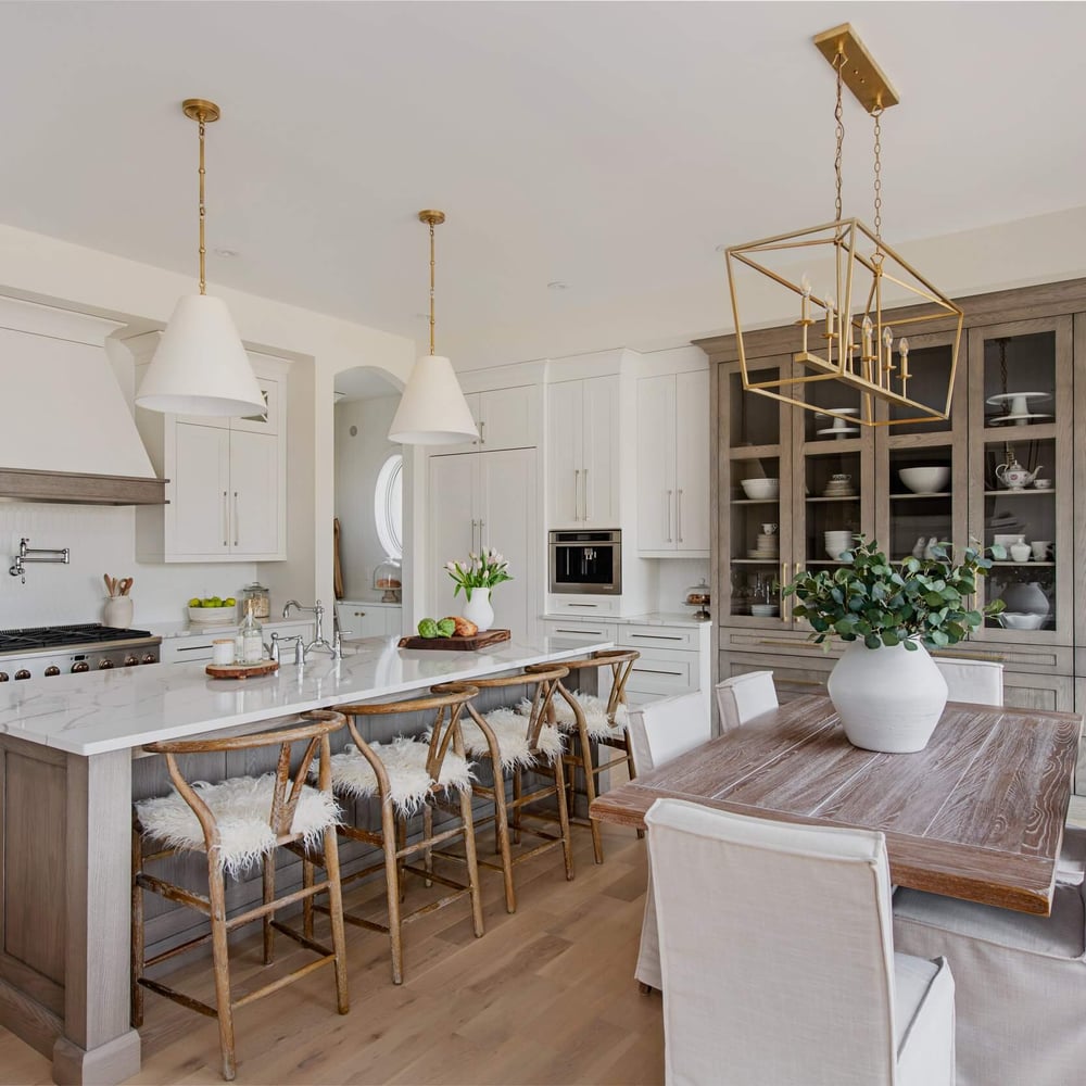 Jillian kitchen from Byron Beauty by Casey's Kitchens with neutral white cabinetry, oak accents, and a large marble island under brass pendant lights