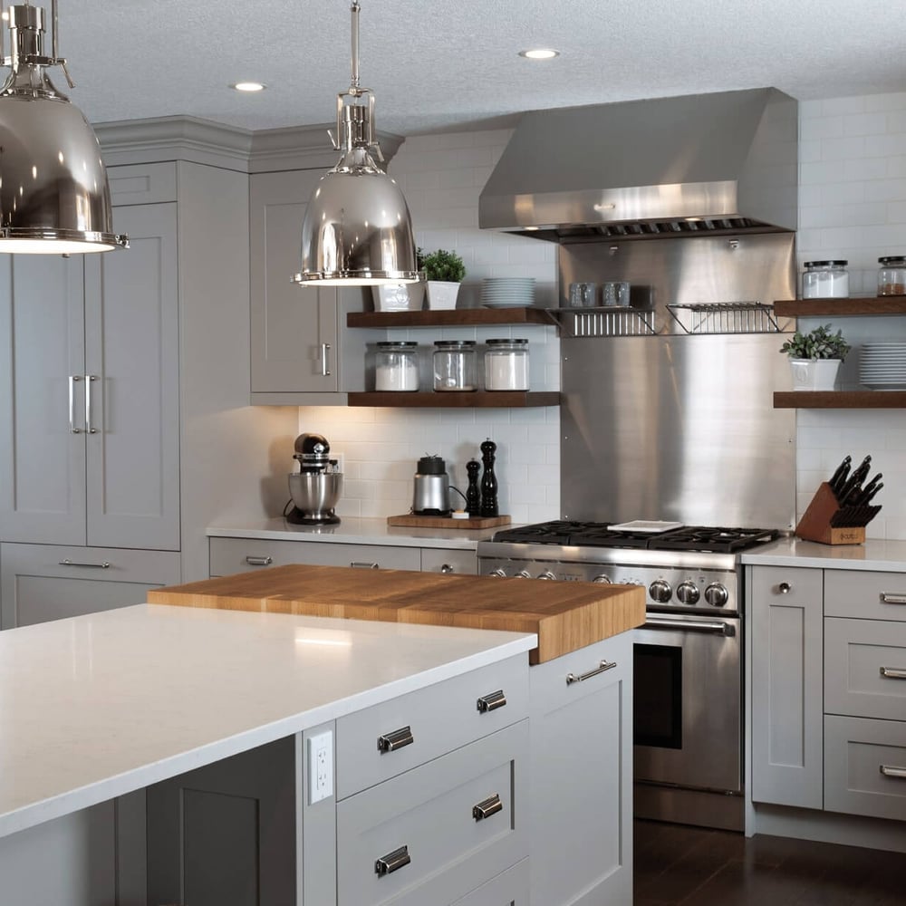 Project_Kitchens_Eastbridge3 Modern kitchen with gray cabinetry, stainless steel appliances, and a central island featuring a wooden countertop.