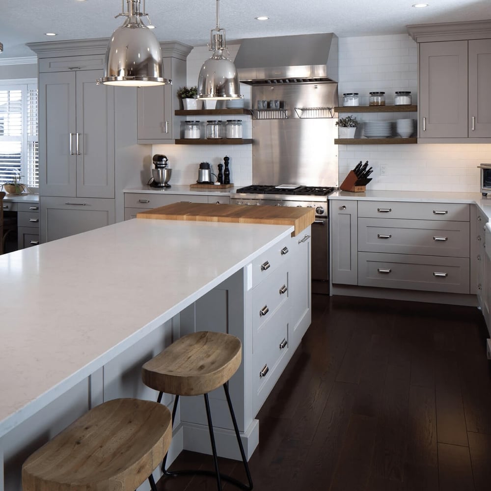 Project_Kitchens_Eastbridge5 Modern kitchen with gray cabinetry, a large island with a wooden countertop, stainless steel appliances, and pendant lighting.
