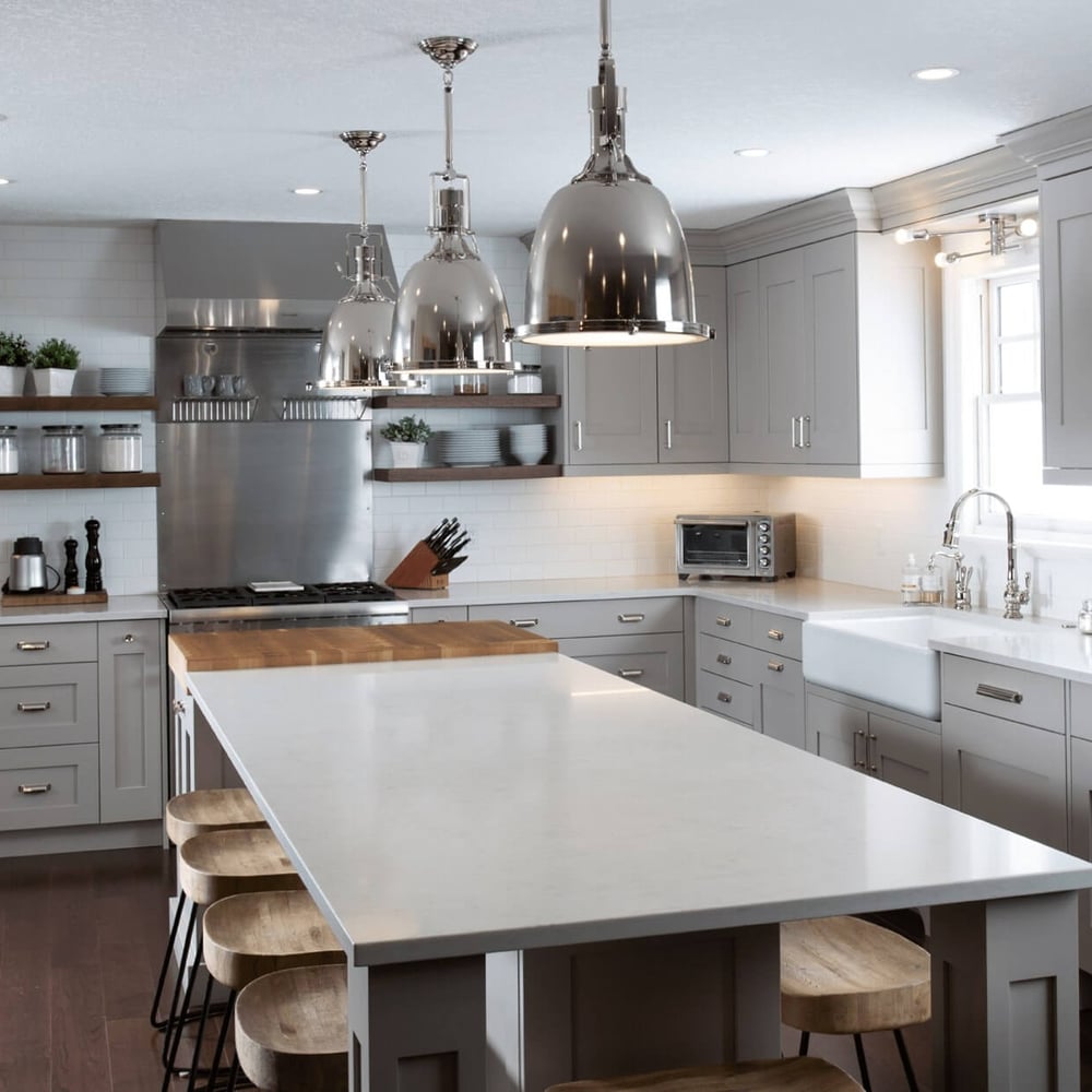 Project_Kitchens_Eastbridge9 Modern kitchen with gray cabinetry, stainless steel appliances, and a large island with wooden stools.