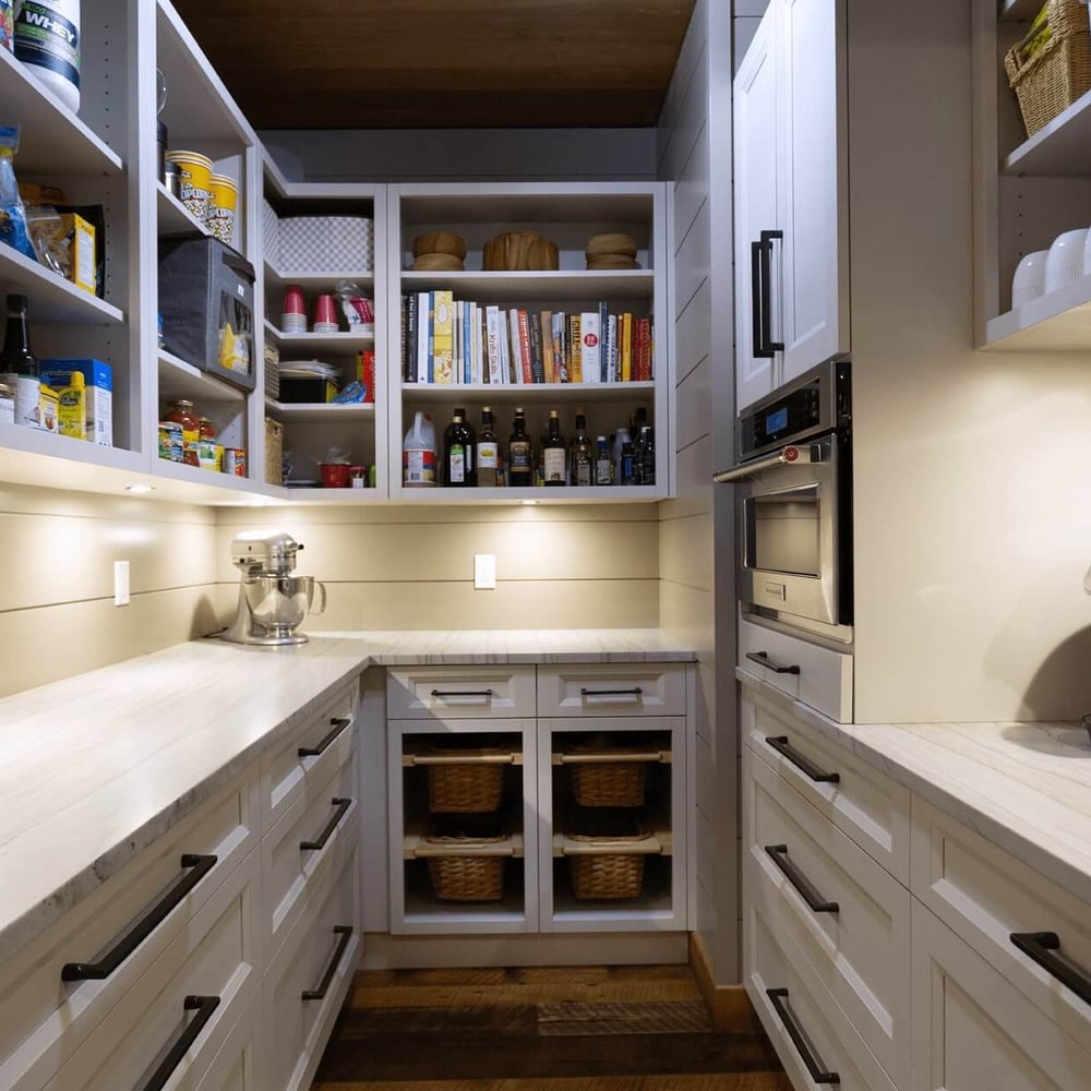 Project_Kitchens_Fruit+Ridge9 Interior view of a modern kitchen pantry with organized shelves, a countertop, and kitchen appliances including a coffee maker.
