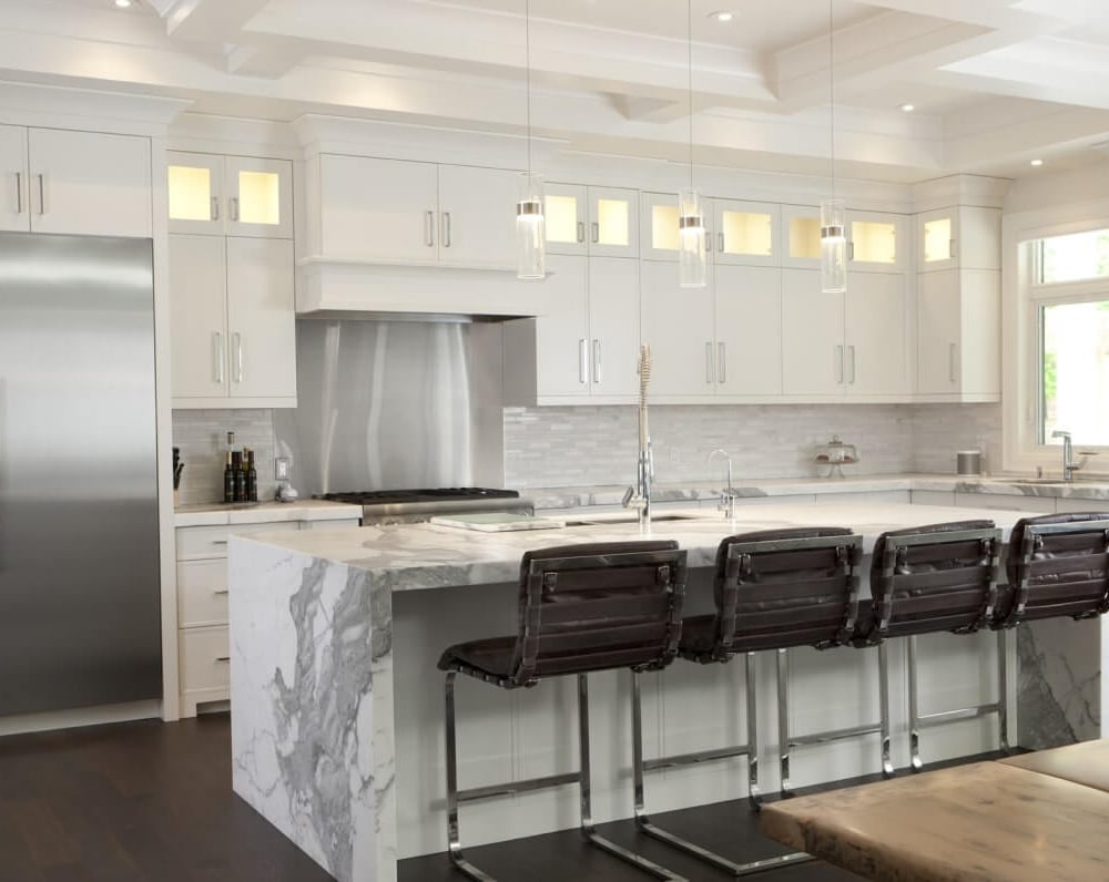 Project_Kitchens_Old+Colonial+Acres1 Modern kitchen with white cabinetry, stainless steel appliances, and a marble island with bar stools.