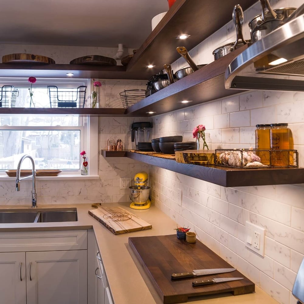 Project_Kitchens_Old+South4 Old South Kitchen project by Casey's Kitchens featuring white cabinetry, a white subway-tiled backsplash, and walnut floating shelves with a stainless steel sink, bright window light, and a yellow mixer