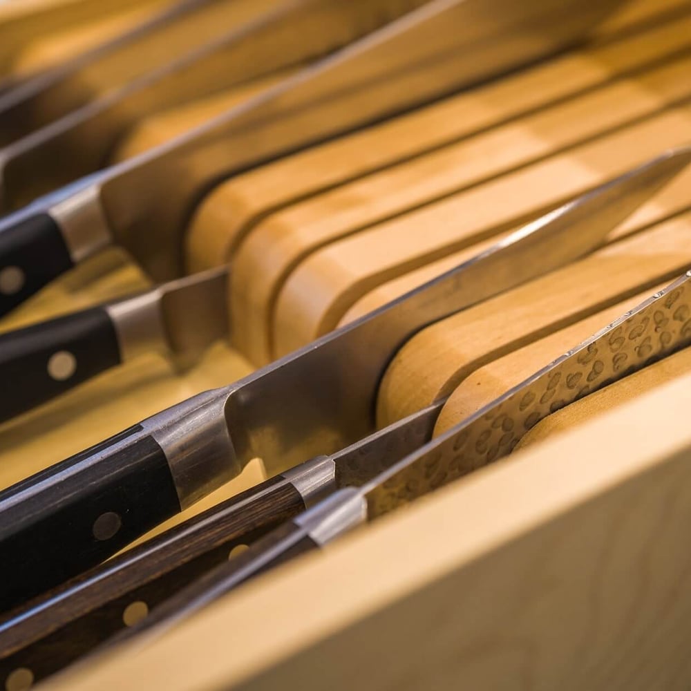 Project_Kitchens_Old+South8 Old South Kitchen close-up of knife block and chef knives with wooden handles and metallic blades, showcasing warm wood tones and precision hardware in a Casey's Kitchens project with Chad Stewart.