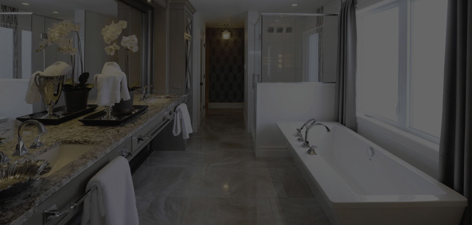 Modern bathroom interior featuring a freestanding bathtub, dual sinks with granite countertops, and elegant fixtures.