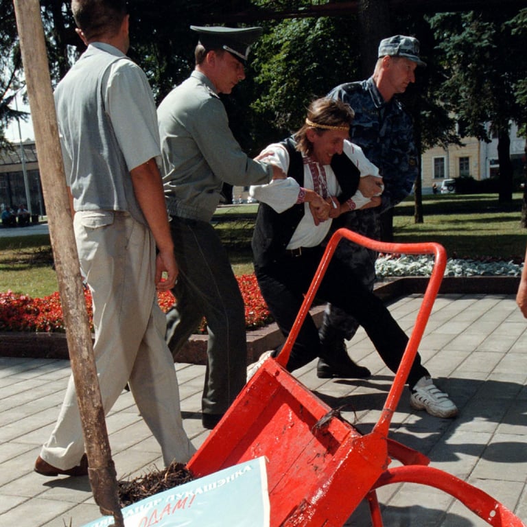 Сотрудники милиции пытаются задержать художника Алеся Пушкина после того, как он привез тележку с навозом к администрации президента Беларуси в Минске, 21 июля 1999 года. Фото: Reuters / Scanpix / LETA