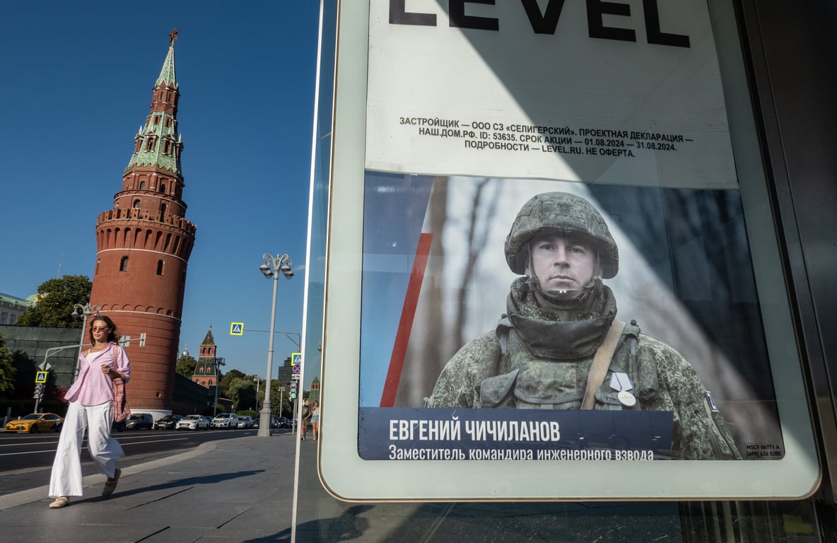 A woman walks past a poster calling on people to enlist in the Russian military outside the Kremlin in Moscow, 19 August 2024. Photo: EPA / YURI KOCHETKOV