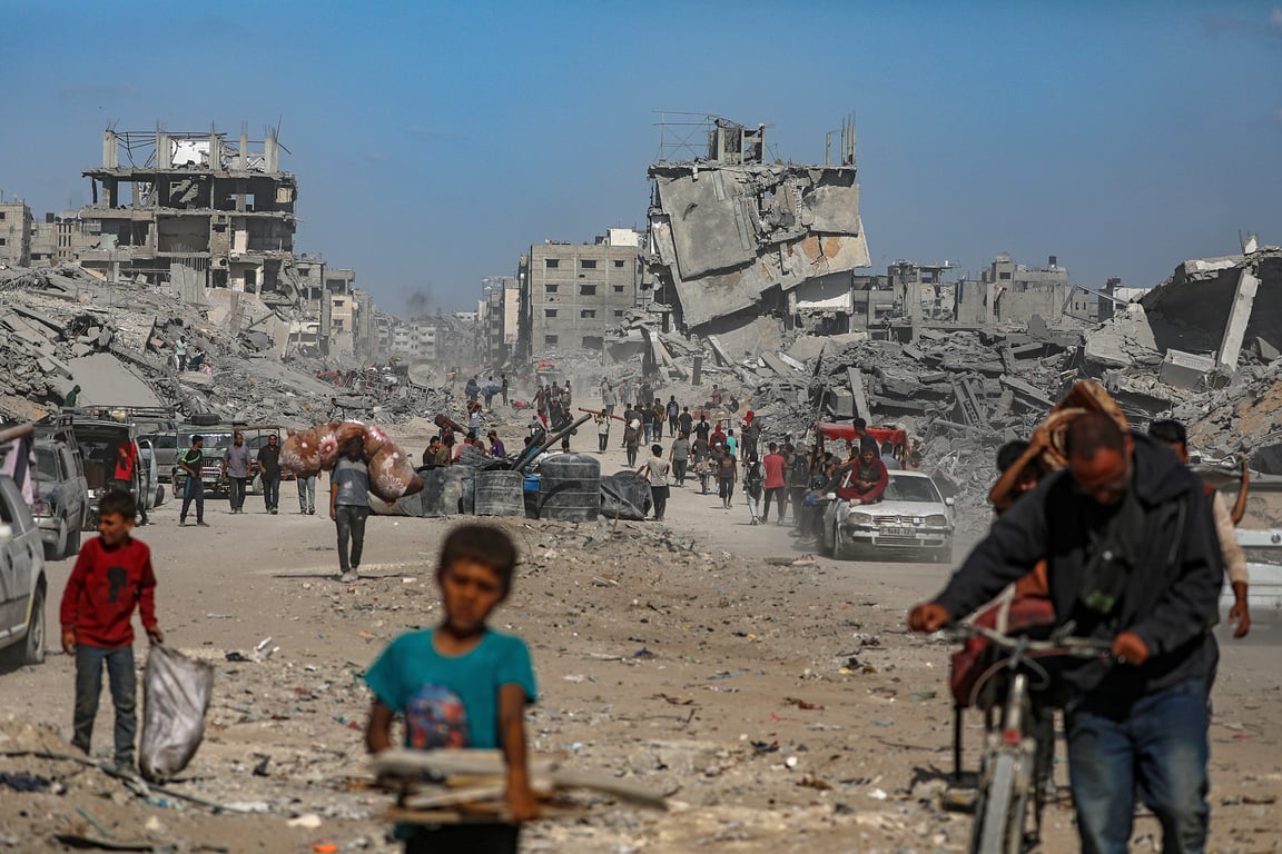 Displaced Palestinians walk through the rubble of Gaza City, 11 October 2025. Photo: EPA / Mohammed Saber