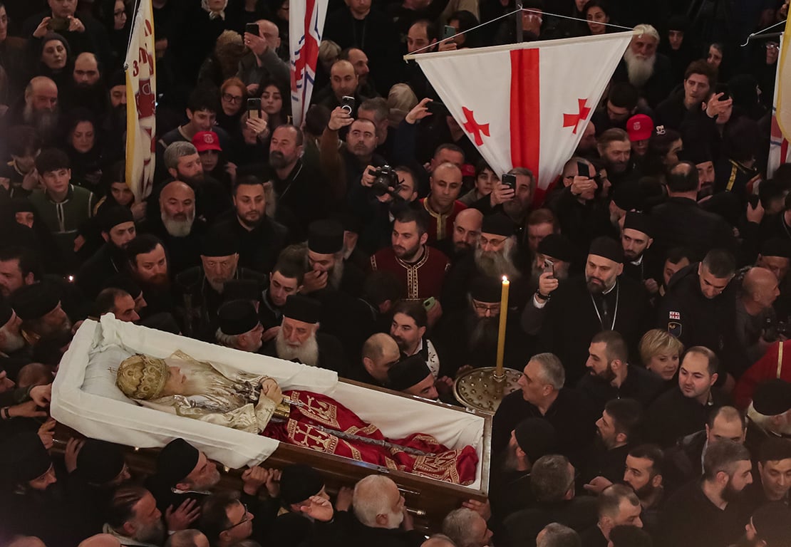 Проводы покойного Патриарха Грузинской православной церкви Илии II толпой скорбящих перед началом поминальной службы в кафедральном соборе Самеба в Тбилиси, Грузия, 18 марта 2026 года. Фото: David Mdzinarishvili / EPA