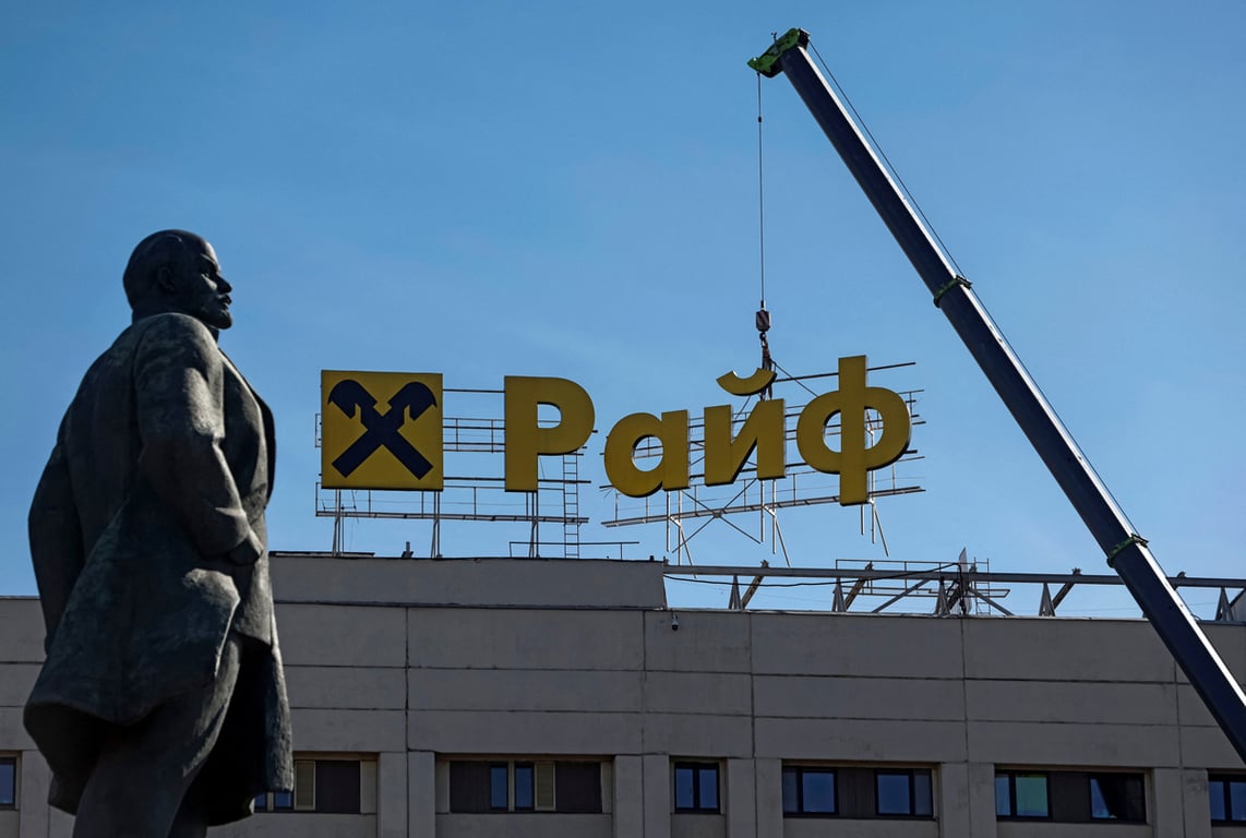 Рабочие с помощью крана демонтируют вывеску Райффайзен Банка с фасада здания, Москва, 14 апреля 2023 года. Фото: Максим Шеметов / Reuters / Scanpix / LETA