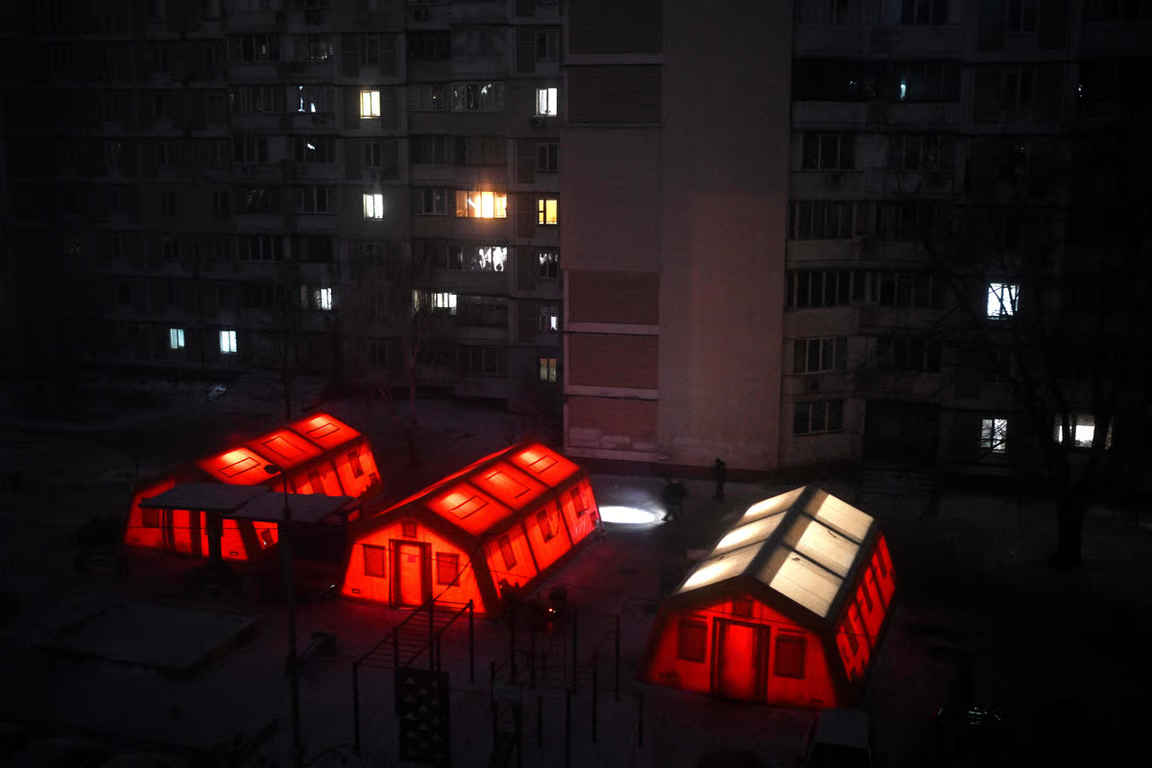 Locals with torches pass heated tents in the courtyard of a residential building amid power cuts, Kyiv, Ukraine, 19 January 2026. Photo: Sergey Gapon / AFP / Scanpix / LETA