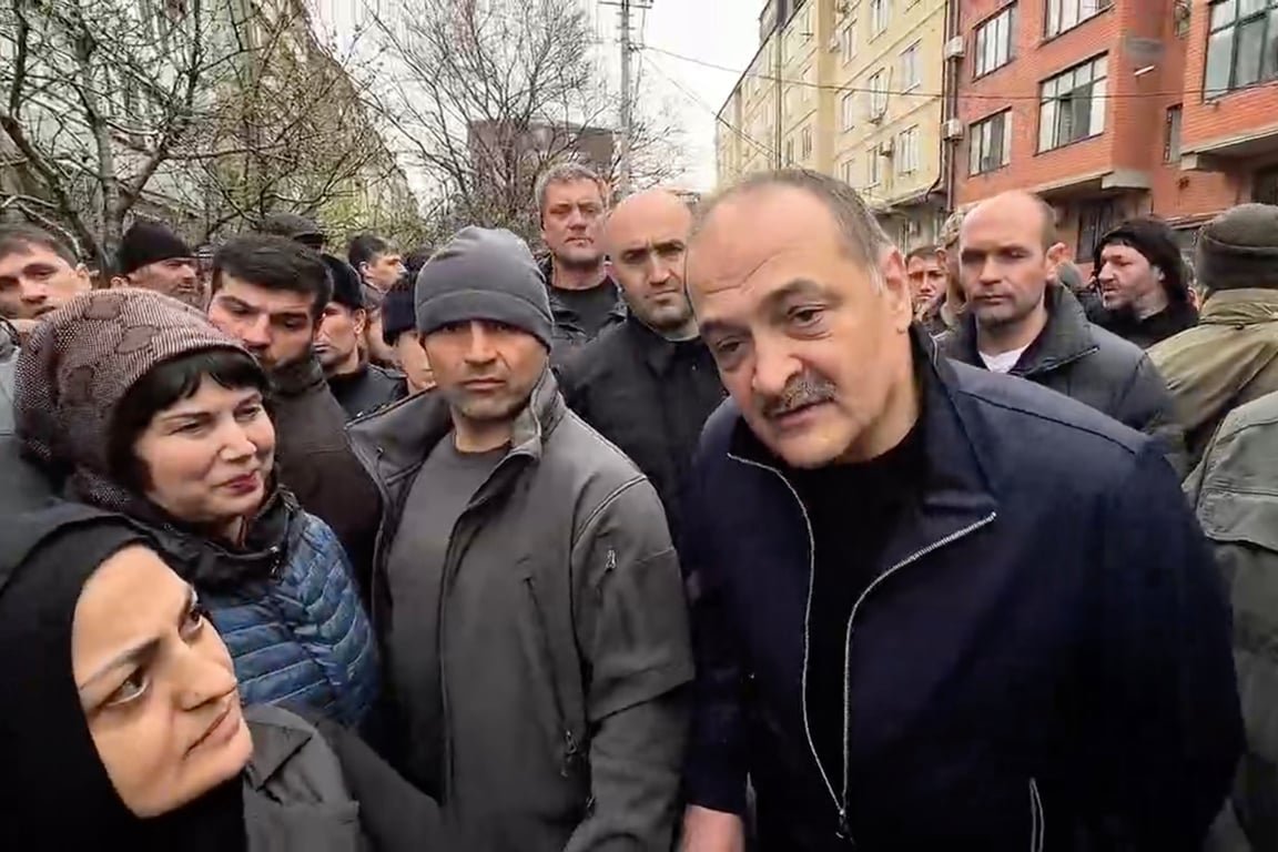 Сергей Меликов (справа) беседует с жителями в зоне подтопления рядом с обрушившимся жилым домом на улице Айвазовского в Махачкале, 6 апреля 2026 года. Фото: МЧС России / AP / Scanpix / LETA<br>