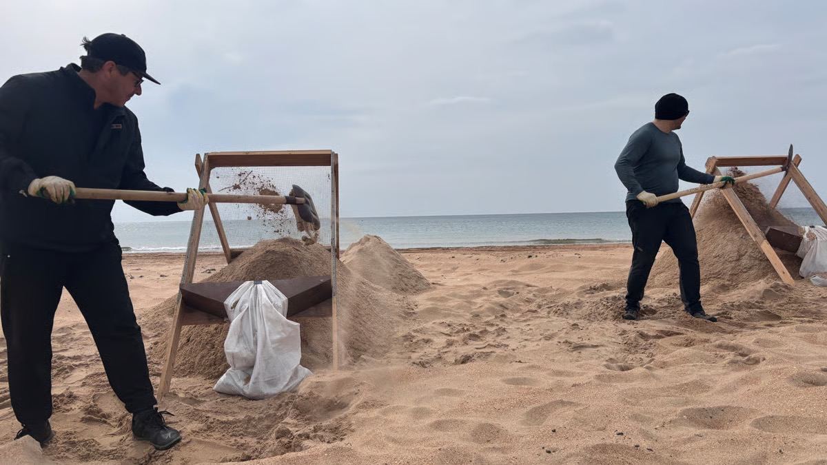 Volunteers sift sand to remove oil. Photo provided by volunteers.