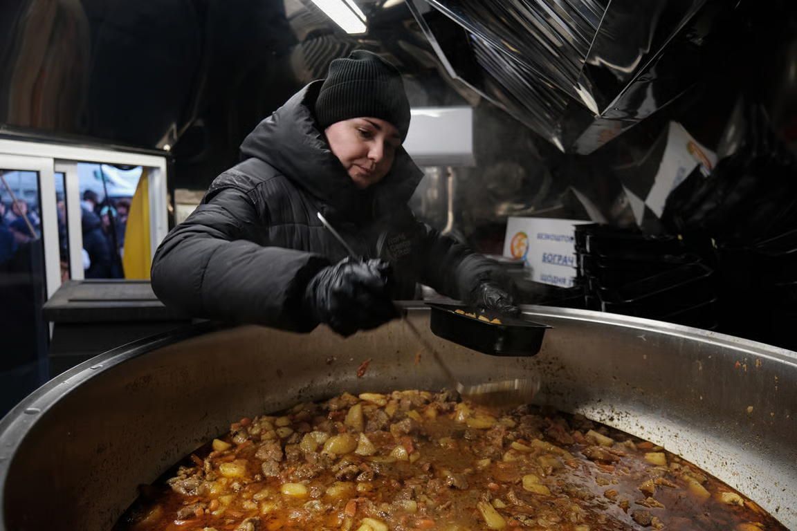 A charity worker from World Central Kitchen distributes hot food in a residential area amid cuts to power and heating, Kyiv, Ukraine, 17 January 2026. Photo: María Senovilla / EPA