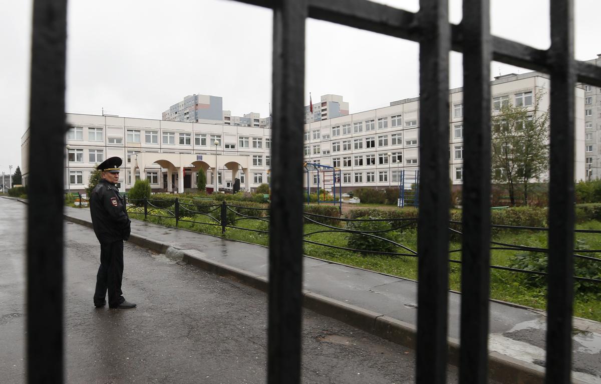 Сотрудник МВД стоит в оцеплении у здания школы в подмосковной Ивантеевке после нападения подростка на учителя, 5 сентября 2017 года. Фото: Максим Шеметов / Reuters / Scanpix / LETA