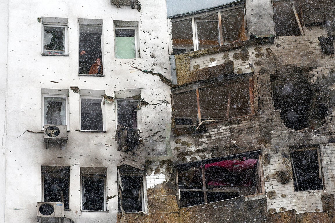 Местные жители выглядывают из разбитых окон после удара российского беспилотника по высотному зданию в Киеве, Украина, 9 января 2026 года. Фото: Анатолий Степанов / SIPA / Scanpix / LETA