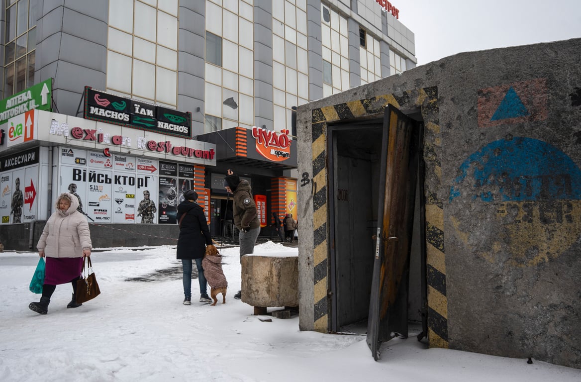 Местные жители проходят мимо уличного укрытия, поврежденного во время атаки беспилотников в Краматорске, Донецкая область, Украина, 18 февраля 2026 года. Фото: Tommaso Fumagalli / EPA