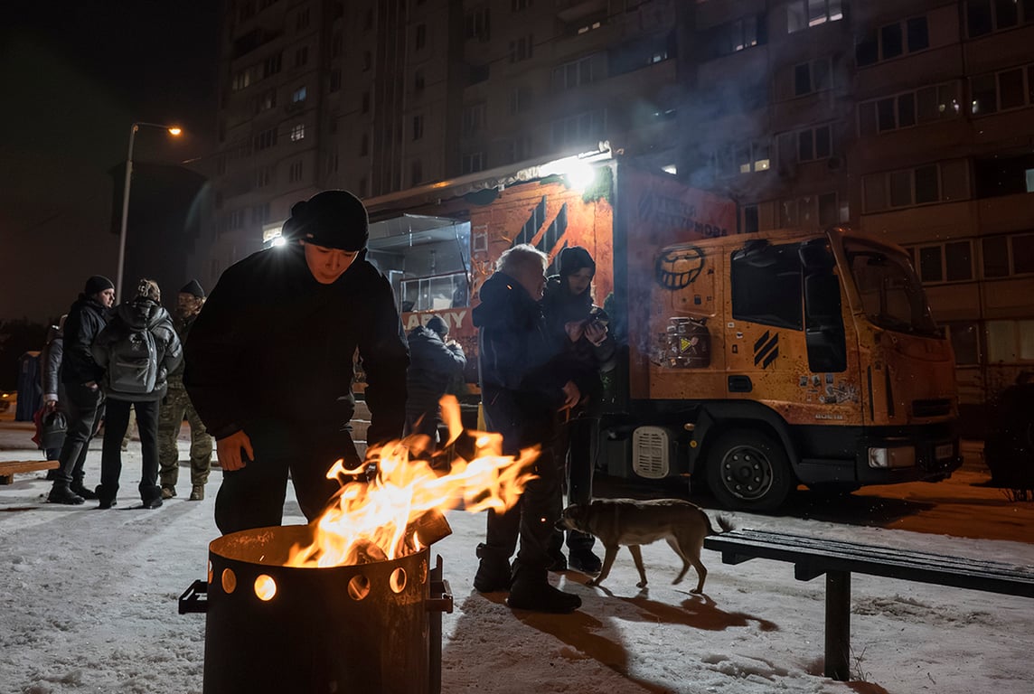 Жители вокруг костра у передвижной кухне в Киеве, Украина, 28 января 2026 года. Фото: Maxym Marusenko / EPA