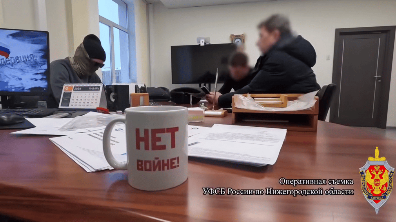 A screenshot from the FSB video of Mikhail Shcherbakov’s detention, showing a mug on his desk saying ”No to war!“