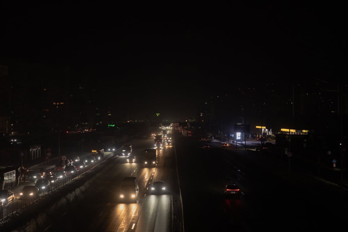 Автомобили движутся по неосвещённому проспекту Киева во время отключения электричества, Украина, 20 января 2026 года. Фото: Roman Pilipey / AFP / Scanpix / LETA