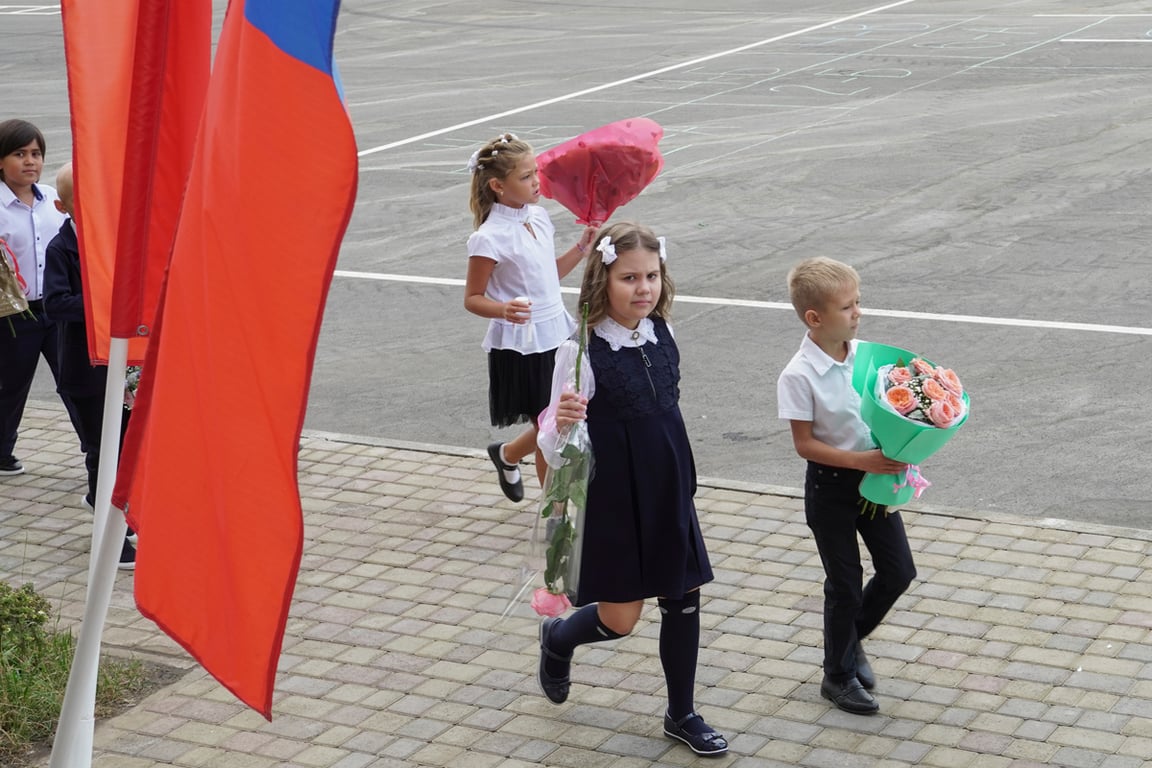 Ученики у здания школы после церемонии в честь Дня знаний в Мариуполе, Украина, 1 сентября 2023 года. Фото: EPA