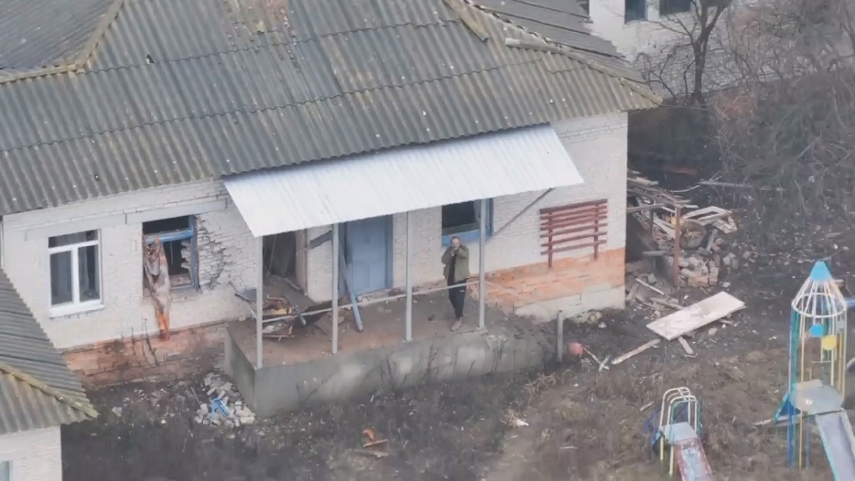 Мужчина направляет автомат на российский дрон в Грабовском, Сумская область, Украина, 2025 год. Скриншот из видео: Александр Коц /  Telegram