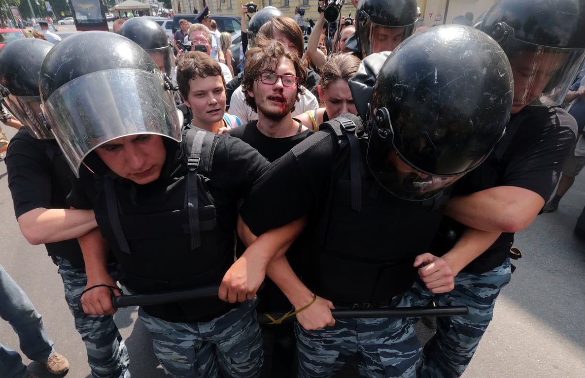Police officers surround an LGBT rights activist who was injured during clashes with anti-gay protesters during a Pride rally in St. Petersburg, Russia, 29 June 2013. Photo: EPA / Anatoly Maltsev