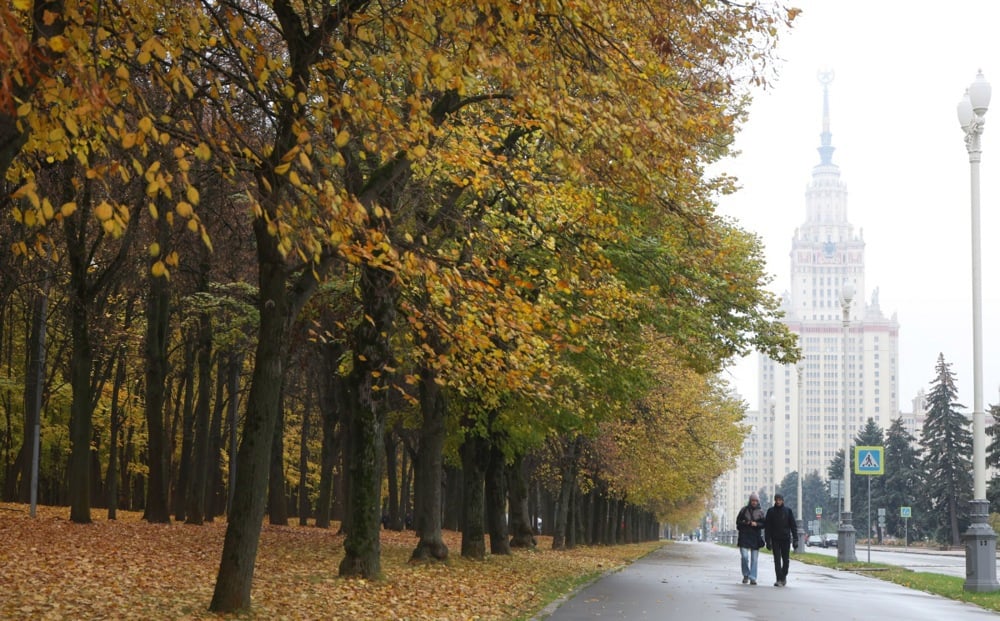 People walk in a park outside the main building of Moscow State University on 20 October 2025. EPA/MAXIM SHIPENKOV