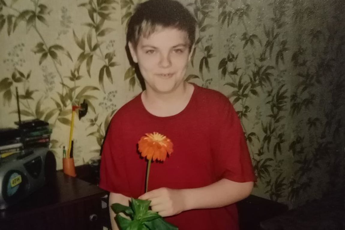 Артем в детстве с цветком цинии, который он вырастил, 2003 год. Фото из семейного архива Хорошиловых / «Новая газета.Балтия»