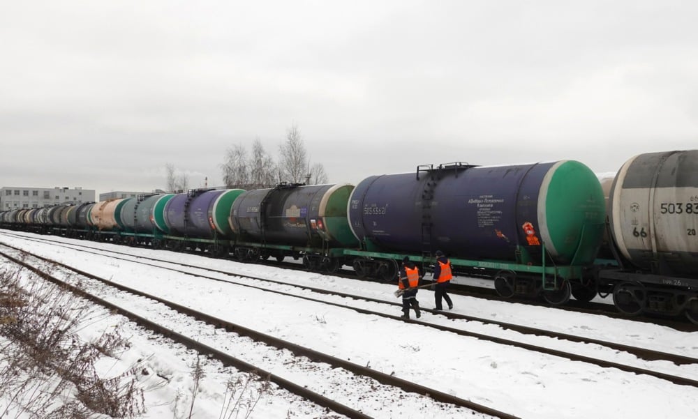 Workers walk in front of railway tankers carrying oil products outside Moscow, Russia, 6 February 2023. Photo: EPA/MAXIM SHIPENKOV