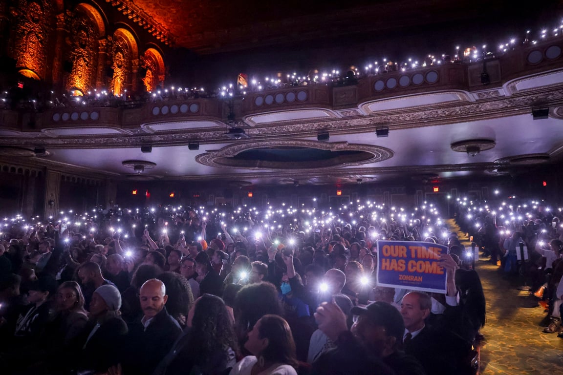 Участники митинга «Our Time Has Come» («Наше время пришло»), организованного демократическим кандидатом в мэры Нью-Йорка Зохраном Мамдани, освещают зал фонариками своих телефонов в театре United Palace, Нью-Йорк, США, 13 октября 2025 года. Фото: Sarah Yenesel / EPA