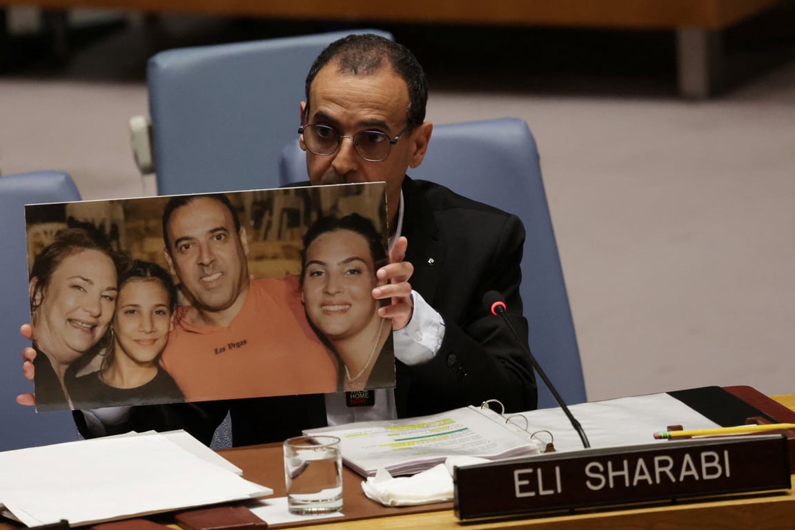 Эли Шараби показывает фотографию своей жены и дочерей, убитых Хамасом, во время выступления в Совете Безопасности ООН в Нью-Йорке, США, 20 марта 2025 года. Фото: Mike Segar / Reuters / Scanpix / LETA