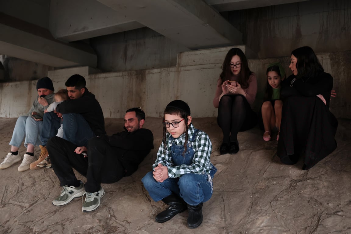 Люди укрываются под мостом во время сигнала воздушной тревоги в районе международного аэропорта имени Бен-Гуриона, Израиль, 2 марта 2026 года. Фото: Abir Sultan / EPA