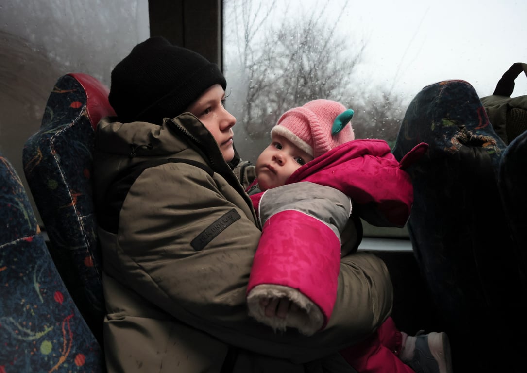 A 14-year-old boy carries his nine-month-old sister as they are evacuated from their home in southeastern Ukraine’s Zaporizhzhia region, 7 January 2026. Photo: EPA / Oleg Movchanuk